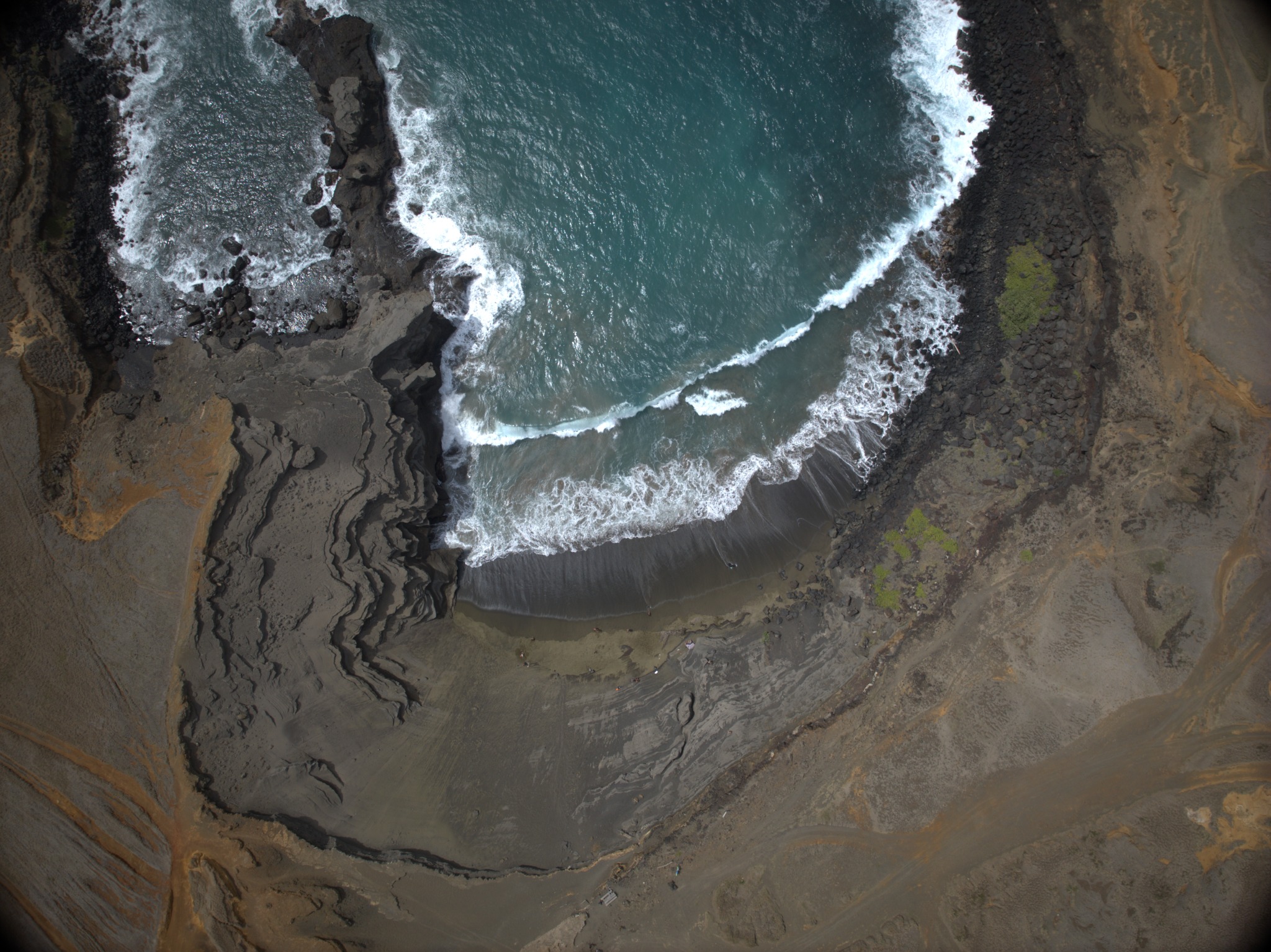 Aerial view of waves meeting a rugged beach on Hawaiʻi Island