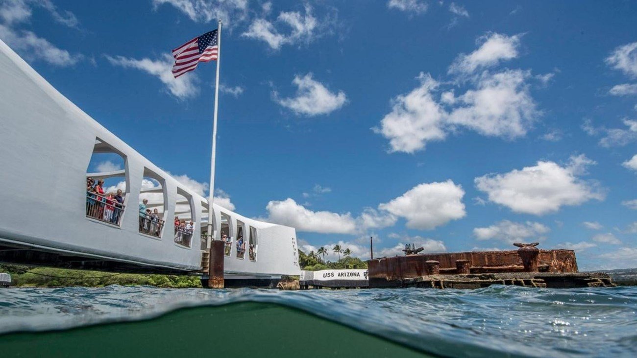 Visitors look through the open windows down to the ship below the surface.